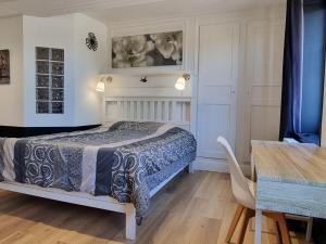 una camera da letto con un letto e un tavolo in una stanza di Gîte Typique des Flandres, 9 Couchages, Grand Jardin, Cheminée, Activités Proches - FR-1-510-16 a Oudezeele