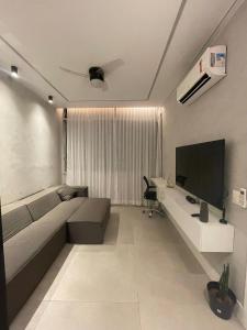 un salon avec un canapé et une télévision à écran plat dans l'établissement Studio Zona Sul Laranjeiras RJ, à Rio de Janeiro