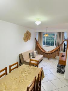 ein Wohnzimmer mit Tisch und Couch in der Unterkunft Apartamento prainha rua da praia in Arraial do Cabo