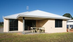 a house with a table and chairs in front of it at Manjimup Gateway Hotel in Manjimup