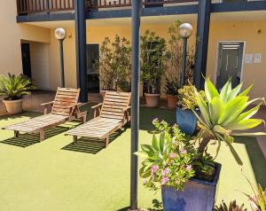 a group of chairs and potted plants on a patio at Ningaloo Club Backpackers in Coral Bay +10 photos