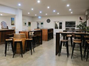 a bar in a restaurant with wooden stools at Manjimup Gateway Hotel in Manjimup