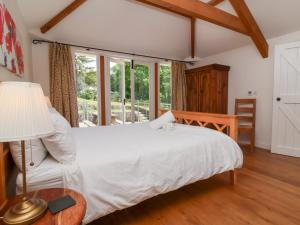 a bedroom with a white bed and a window at Old Maids Cottage in Ilfracombe