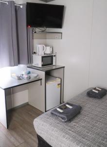 a room with a bed with a microwave and a desk at Manjimup Gateway Hotel in Manjimup