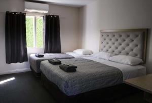 a bedroom with two beds and a window at Manjimup Gateway Hotel in Manjimup