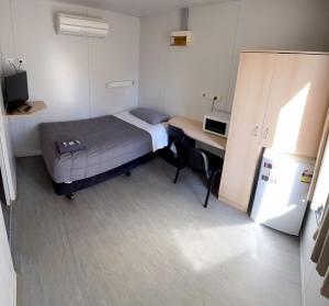 a small bedroom with a bed and a desk at Manjimup Gateway Hotel in Manjimup