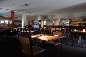 a dining room with wooden tables and chairs at Manjimup Gateway Hotel in Manjimup