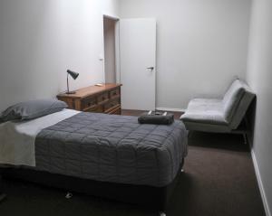 a bedroom with a bed and a couch and a chair at Manjimup Gateway Hotel in Manjimup