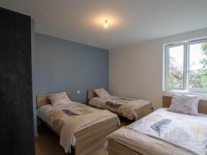 three beds in a room with a window at Gîte rénové avec terrasse et jardin, au cœur de Saint-Mesmin, idéal pour nature et randonnées - FR-1-616-212 in Saint-Mesmin