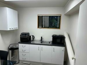 a kitchen with a sink and a microwave at Uniqueness in Tauranga
