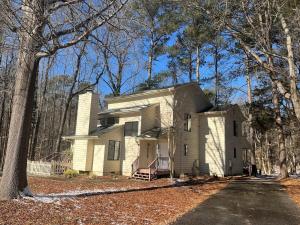 a white house in the middle of the woods at Quiet 2 bedroom house close to UNC Duke RTP in Chapel Hill