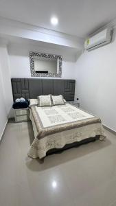 a bedroom with a large bed and a mirror at Hotel Costa Norte in Necoclí