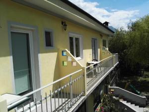 Casa amarilla con balcón con puerta en Hotel Paradise, en Bruzolo
