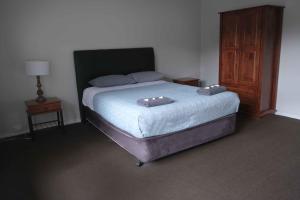 a bedroom with a bed with two pillows on it at Manjimup Gateway Hotel in Manjimup