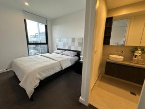 a bedroom with a large bed and a sink at Magnificent Apartment with Views and Pool in Blackburn