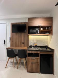a kitchen with wooden cabinets and a counter top at O melhor do Ecoville com sacada - Novinho! in Curitiba