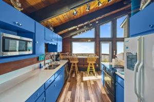 Il comprend une cuisine avec des placards bleus et du parquet. dans l'établissement Stairway to Heaven at Rockaway, à Rockaway Beach