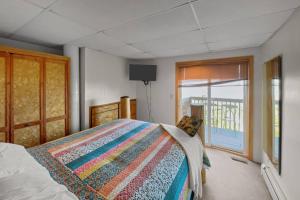 une chambre avec un lit avec une couette colorée dans l'établissement Stairway to Heaven at Rockaway, à Rockaway Beach