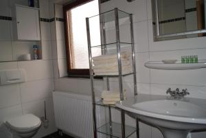 a white bathroom with a sink and a toilet at Hotel Kugel in Trier