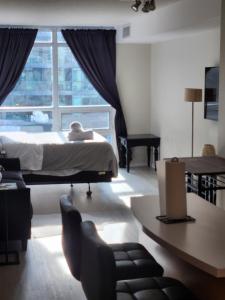 a bedroom with a bed and a large window at Downtown Toronto Cozy Suite in Toronto +15 photos