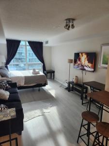 a bedroom with a bed and a couch and a tv at Downtown Toronto Cozy Suite in Toronto