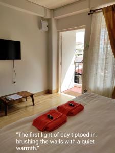 een slaapkamer met een bed met twee rode handdoeken erop bij ARISAN Bed and Breakfast in Shillong