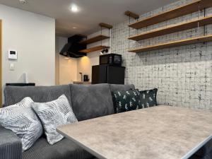 a couch with pillows and a table in a room at エクセル北円山 in Sapporo