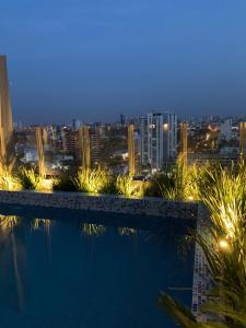 einen Pool mit Stadtblick in der Nacht in der Unterkunft Dpto de lujo en Equipetrol, con piscina in Santa Cruz de la Sierra