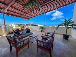 a patio with chairs and tables and a view of the ocean at Kicker Suite in Puerto Baquerizo Moreno