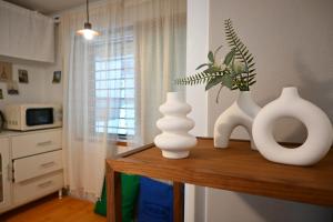 Tres jarrones blancos sobre una mesa en una cocina. en Stay Onjeong Jamsil Accommodation, en Seúl
