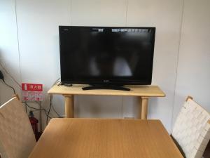 una televisione seduta sopra un tavolo di legno di Everyone's house Nikko みんなの家日光 a Nikko