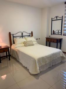 a bedroom with a bed and two tables and a mirror at En Equipetrol, dpto de lujo, 2 plazas in Santa Cruz de la Sierra