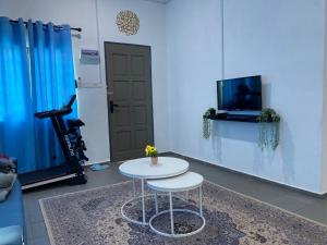 a room with a table and a tv and a door at Homestay Kita in Kuala Terengganu