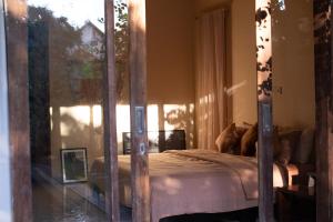 a bedroom with a four poster bed with a window at Tropical Escape 2min Walk to Beach and Private Pool in Cemagi +46 photos