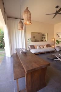 a living room with a table and a couch at Tropical Escape 2min Walk to Beach and Private Pool in Cemagi