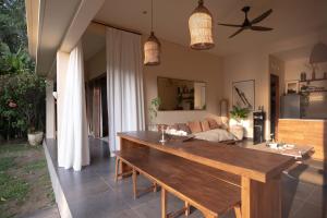 a living room with a table and a couch at Tropical Escape 2min Walk to Beach and Private Pool in Cemagi