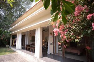 a porch of a house with pink flowers at Tropical Escape 2min Walk to Beach and Private Pool in Cemagi