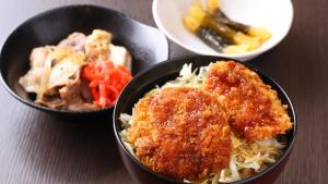 two bowls of food with meat and vegetables on a table at Dormy Inn Express Koriyama in Koriyama