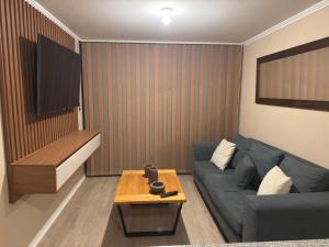 a living room with a blue couch and a table at Departamento en Ulriksen 2 in La Serena