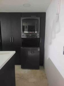 Una habitación con un televisor y un pequeño electrodoméstico. en Urban 3rd floor Condo 3bed3bath 6guest max no elevator, en Envigado