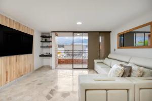 Una sala de estar con un sofá y un televisor de pantalla plana. en Urban 3rd floor Condo 3bed3bath 6guest max no elevator, en Envigado 4 fotos más