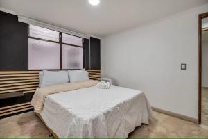 Un dormitorio con una gran cama blanca con ventana. en Urban 3rd floor Condo 3bed3bath 6guest max no elevator, en Envigado