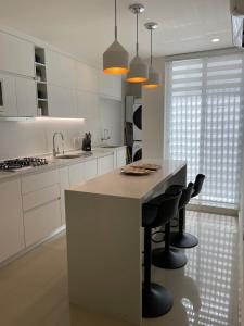 a kitchen with a island with black bar stools at Excellent apartment in Chapalita, everything new in Guadalajara