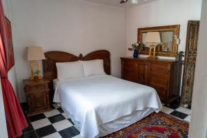 una camera da letto con un letto, un comò e uno specchio di Art and garden home a San Miguel de Allende