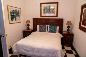 a bedroom with a bed with two night stands and two lamps at Art and garden home in San Miguel de Allende