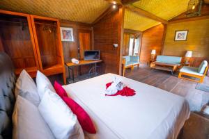 a bedroom with a large white bed with red pillows at The Joglo Beratan in Bedugul