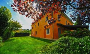 カステルフィダルドにあるCasa Verde Coneroの緑の庭と木のあるオレンジ色の建物