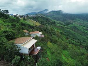 a house on the side of a hill with trees at Baan Rai good view cafe&Resort in Mae Suai