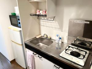 une petite cuisine avec un évier et une cuisinière dans l'établissement 駅南うちやまビル01, à Fukuoka 3 autres photos