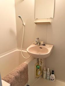 une salle de bain blanche avec un lavabo et une baignoire dans l'établissement 駅南うちやまビル01, à Fukuoka